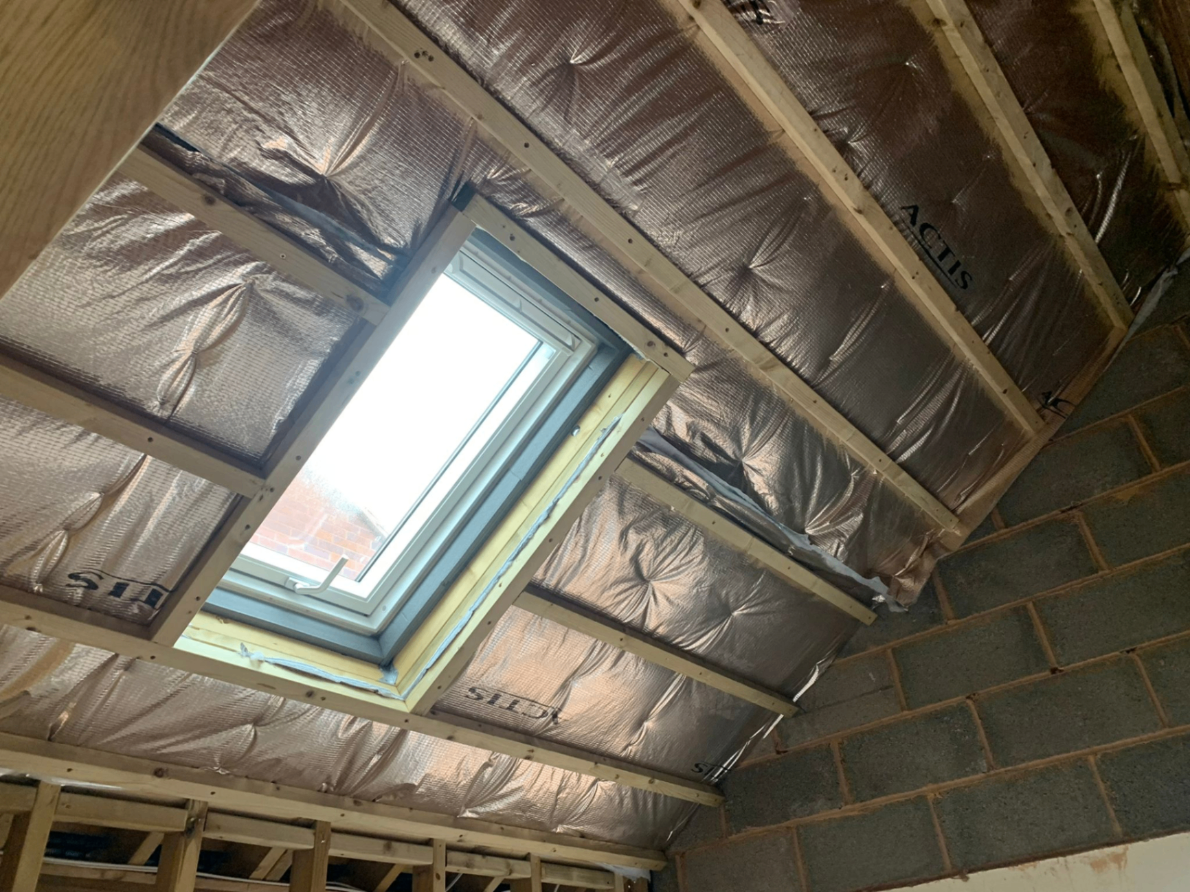 Loft insulation membrane and rafter framing around a Velux skylight fitted by AJW Carpentry, Exeter