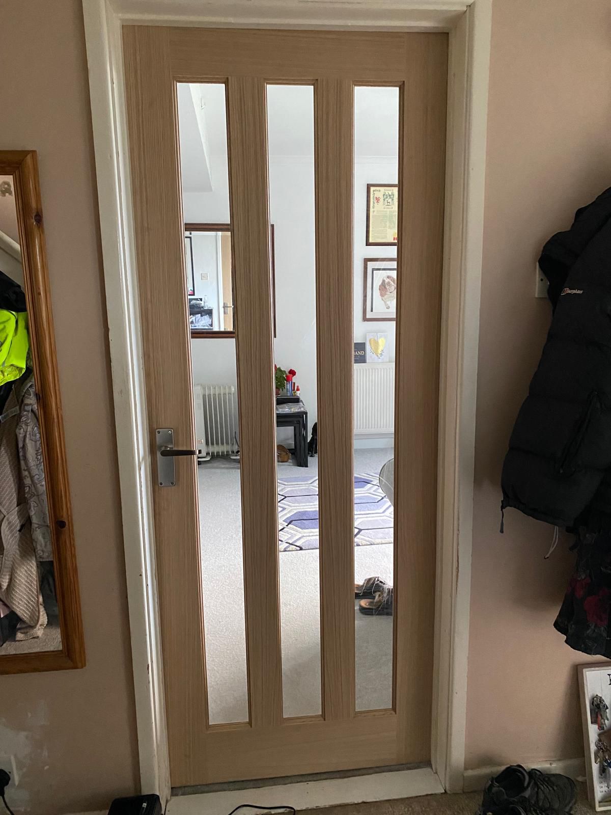Newly fitted oak internal door with vertical glazed panels in a Sidmouth home